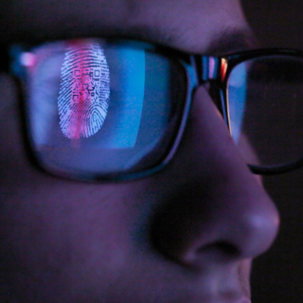 Cyber Security, reflection in spectacles of access information being scanned on computer screen