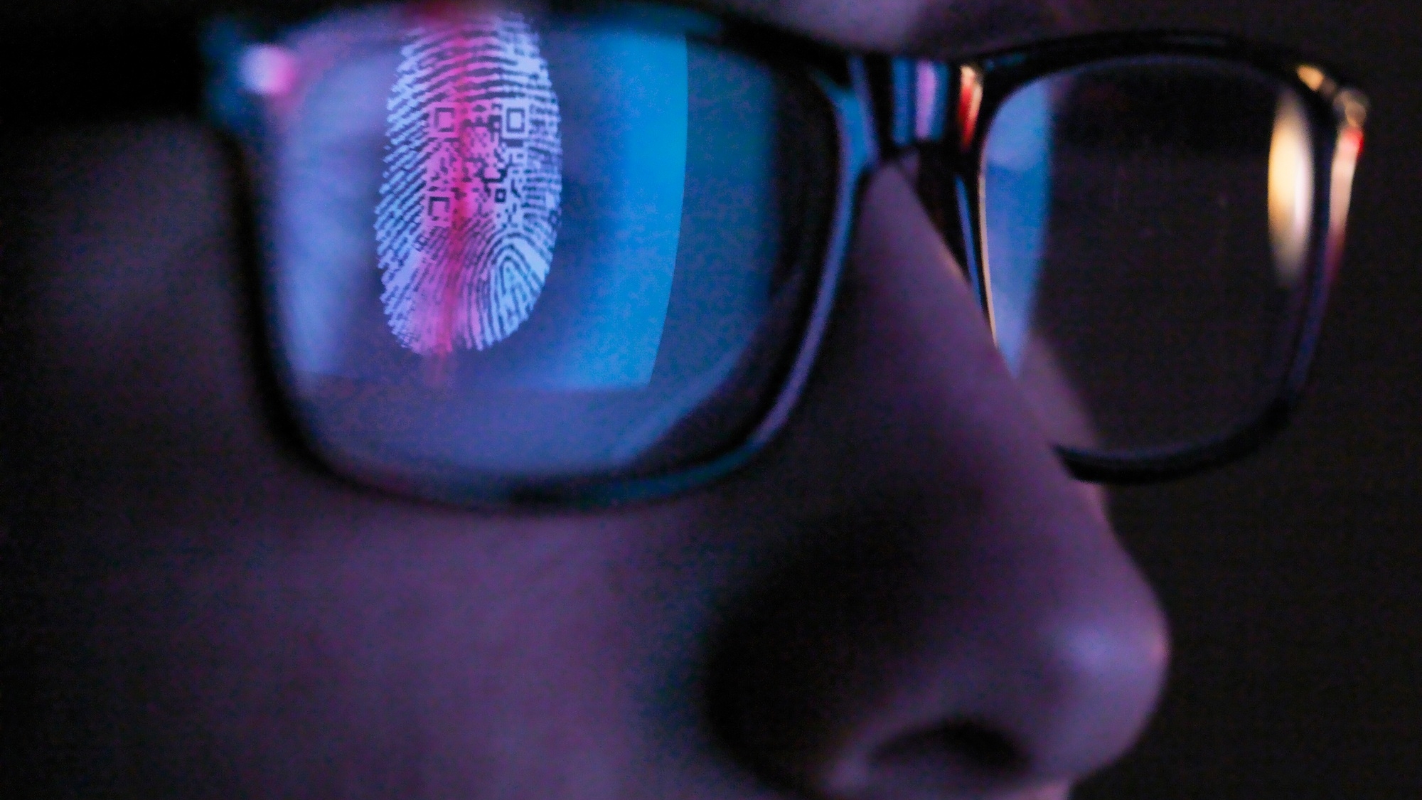 Cyber Security, reflection in spectacles of access information being scanned on computer screen
