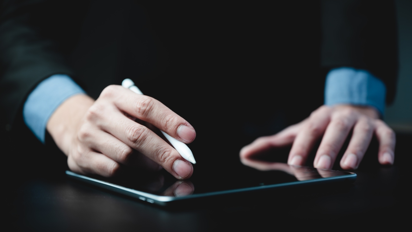 hands of a young successful male entrepreneur and businessman writing on digital tablet