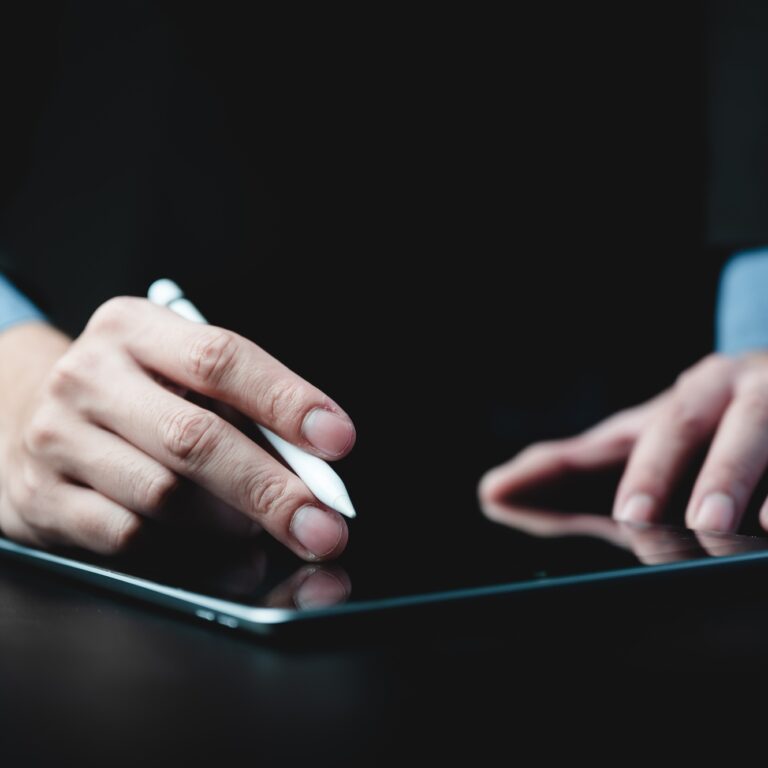 hands of a young successful male entrepreneur and businessman writing on digital tablet