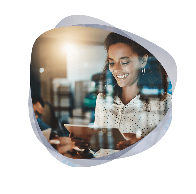 Business owner smiling, looking at her device, which has a notification of an on-time delivery of an ERP implementation.