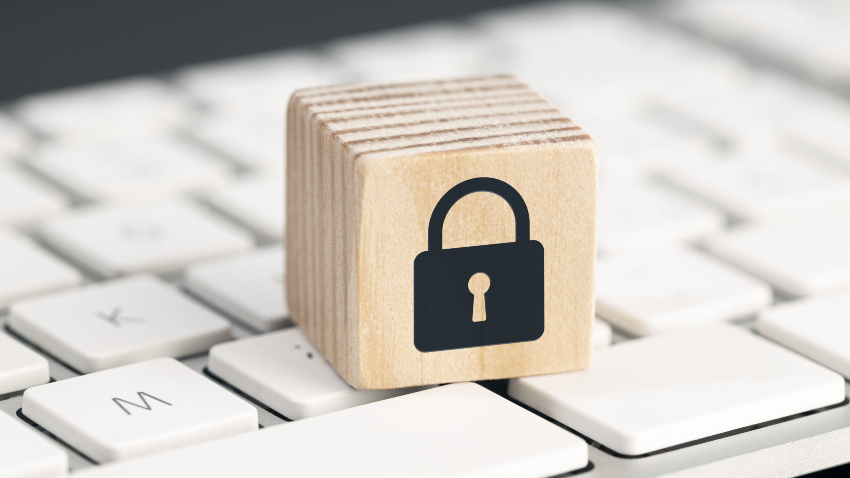 Computer Security protection concept. Cyber attack protection. Closed padlock icon on wooden block on computer keyboard