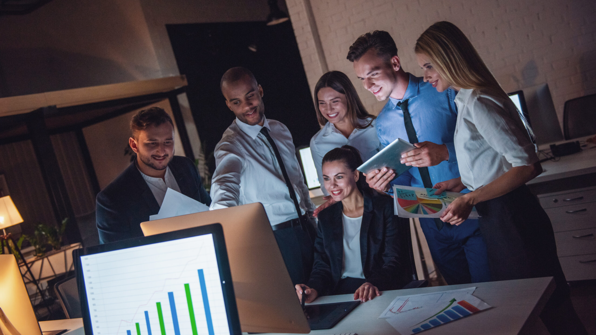 Successful business people are listening to their boss during the conference in office late at night